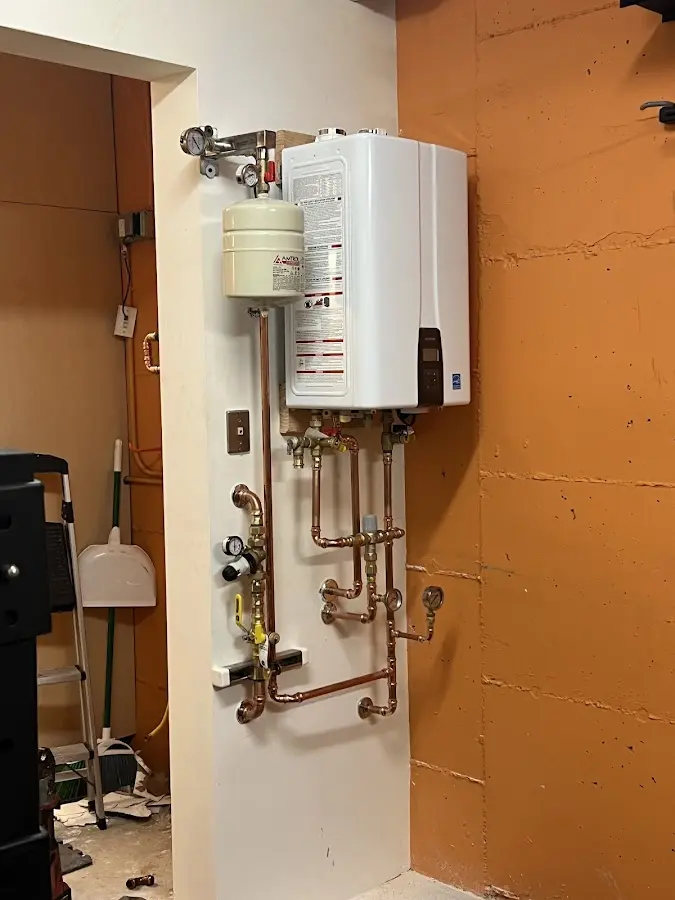 Plumbing technician inspecting water heater connections in Lyon
